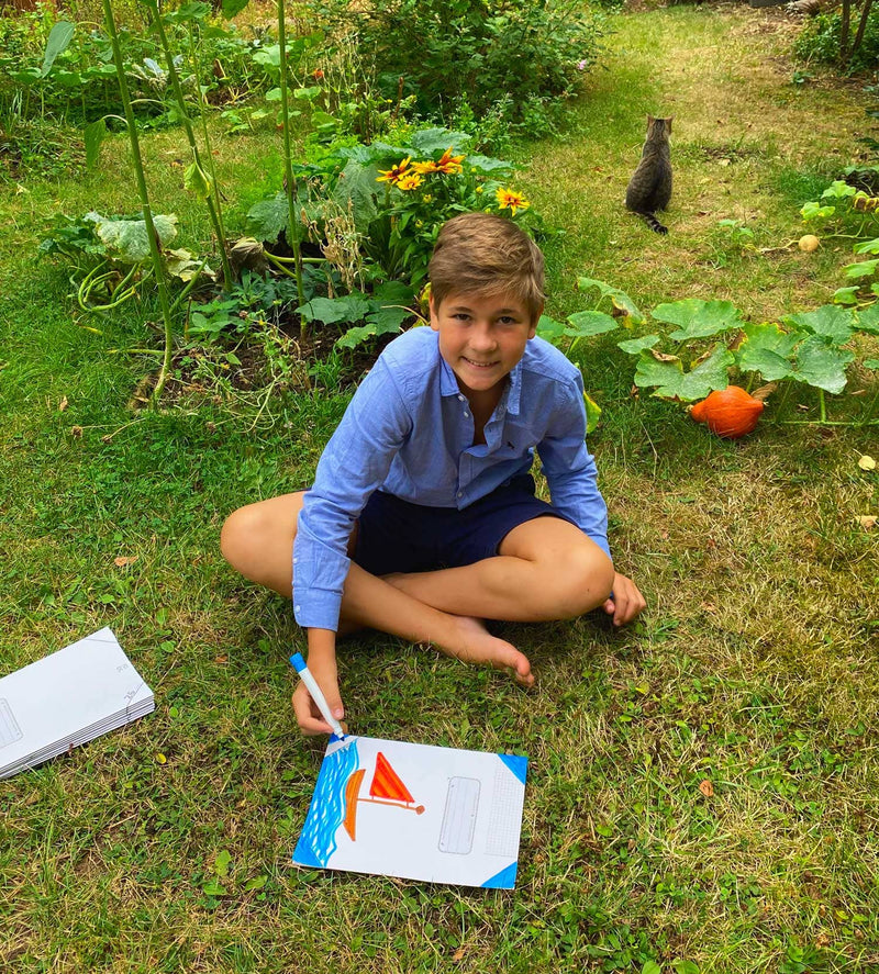 Kind mit Schulheft ohne Plastikumschlag im Garten von soisi | Grüner Gedanke